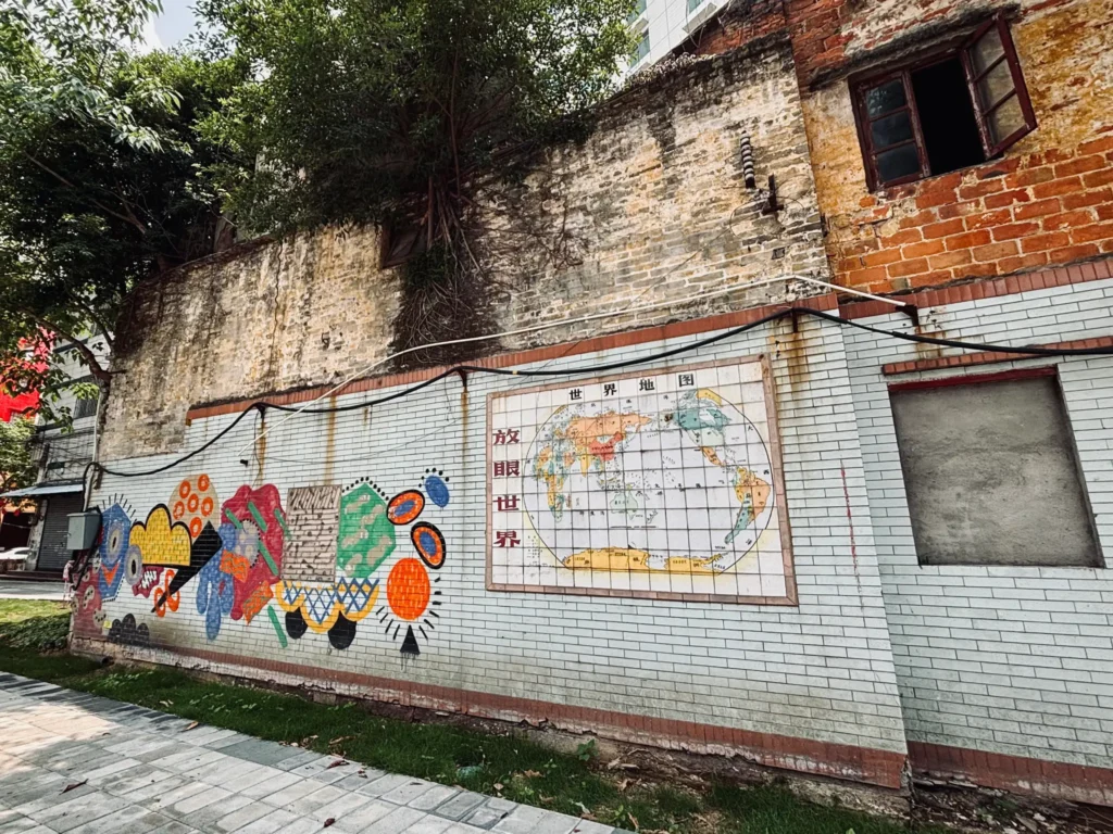 一幅係牆壁上嘅世界地圖，地圖隔離寫著「放眼世界」，伴有抽象風格的圖案設計作裝飾。